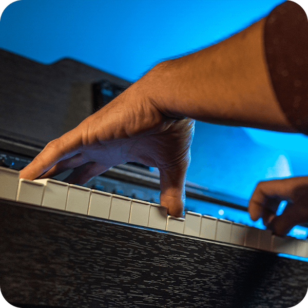 Close up of Williams Rhapsody III digital piano keys with pianist hands.