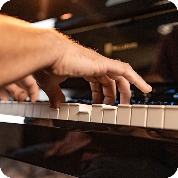 Williams Symphony Concert digital grand piano keys with players hand playing.